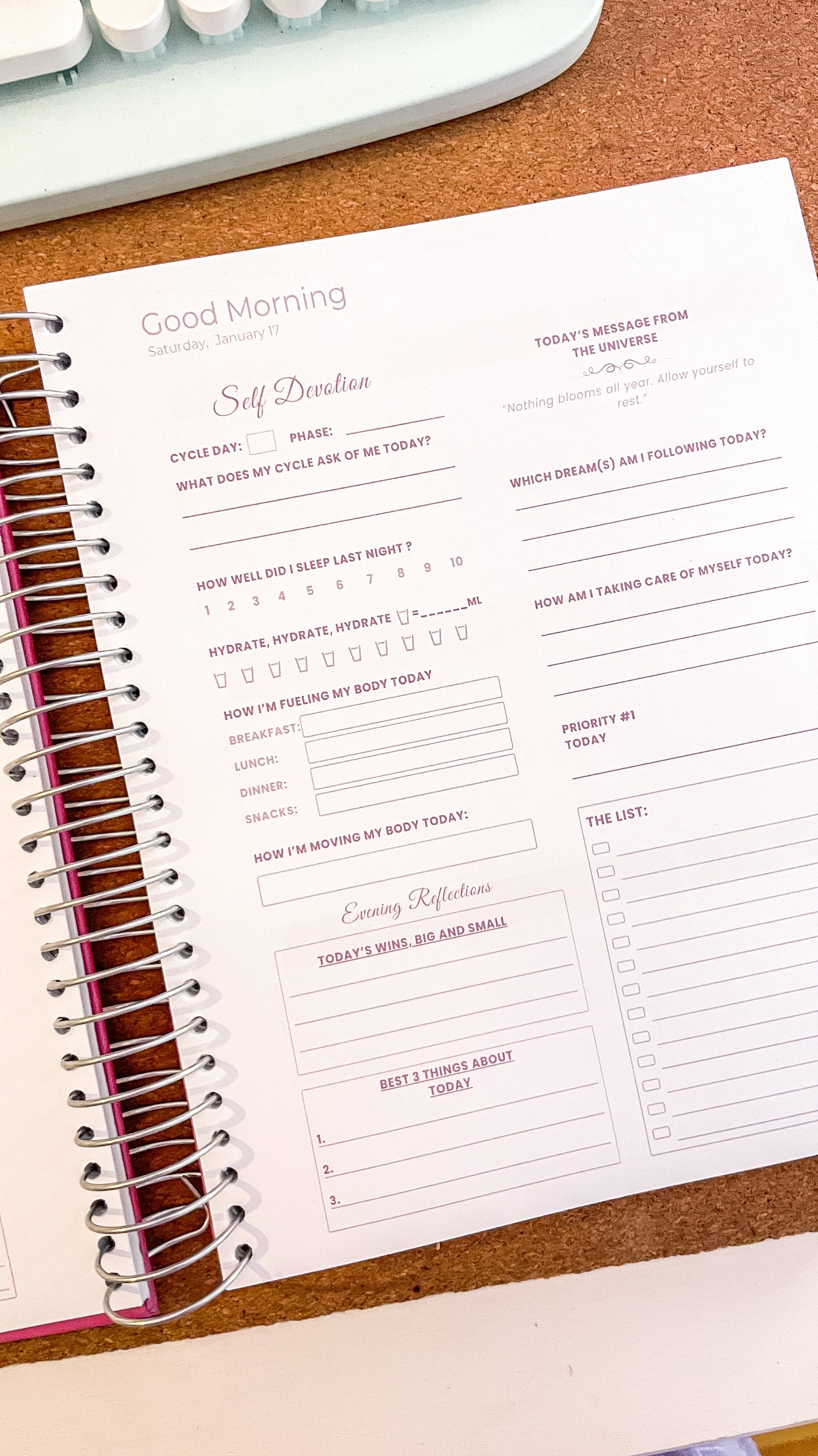 Daily planner/ journal on a desk and keyboard in the background