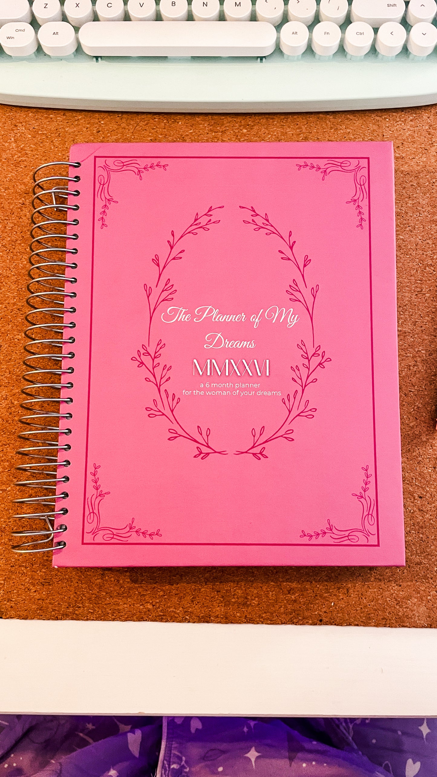 Pink planner with floral design on a wooden surface, The Planner of My Dreams 2026