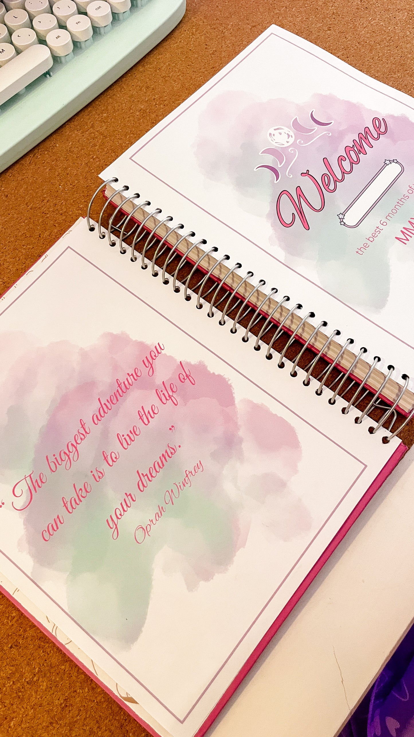 Open spiral-bound notebook with motivational quote by Oprah Winfrey on a wooden surface