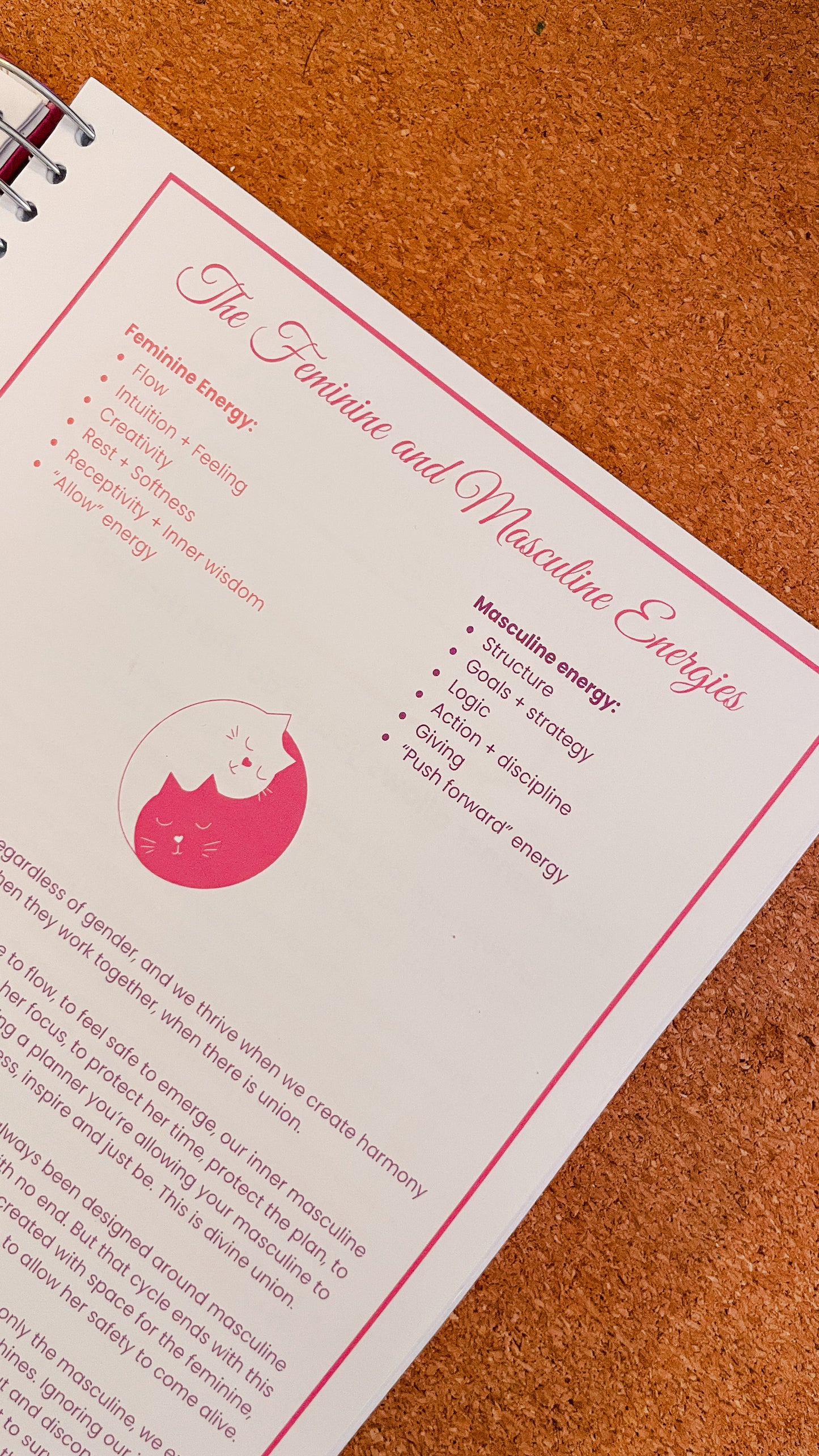Sheet of paper with Feminine and Masculine Energies title and a pink ring and yang kitty sign on a brown surface