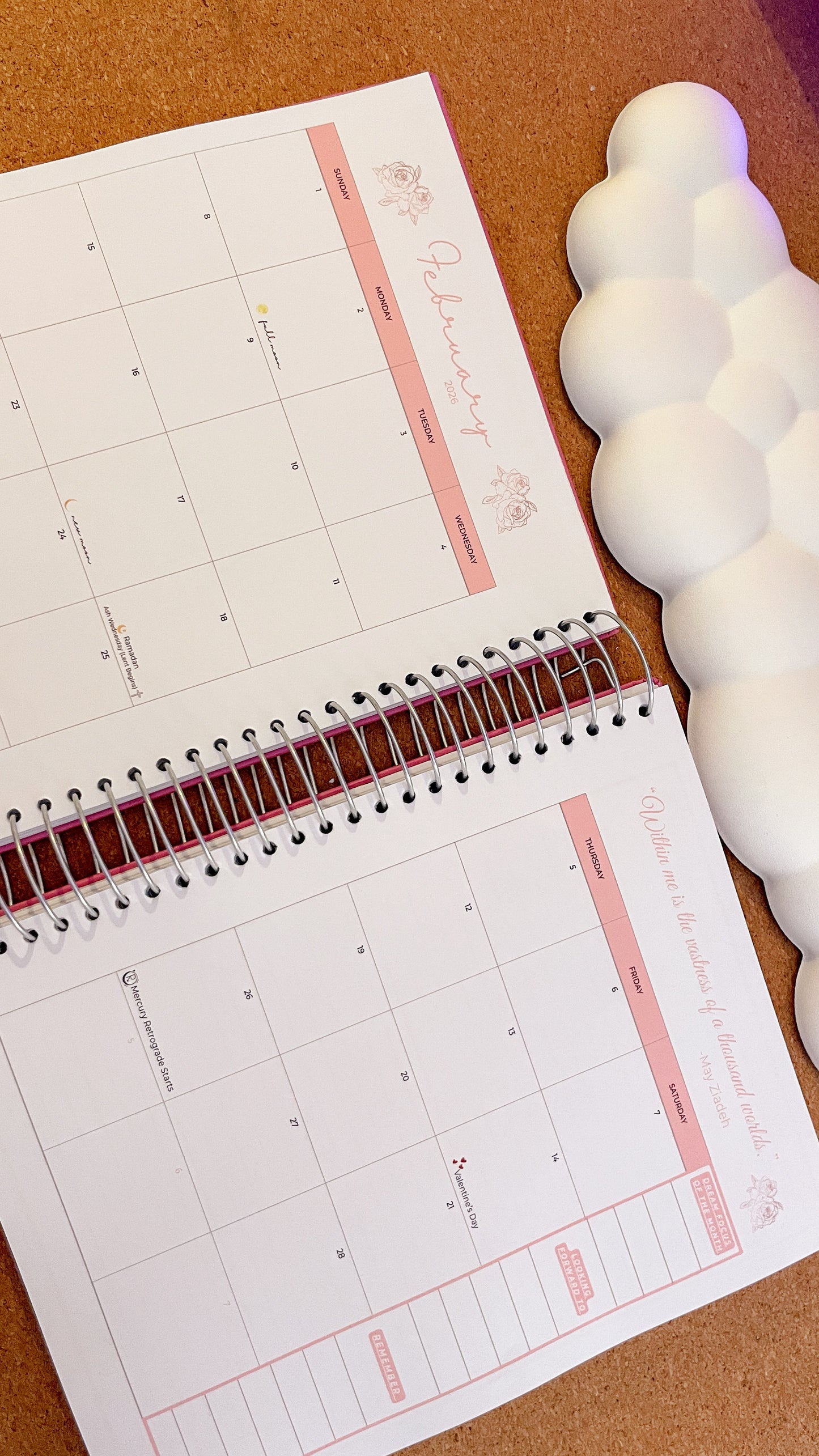 Monthly calendar planner on a wooden surface with decorative items