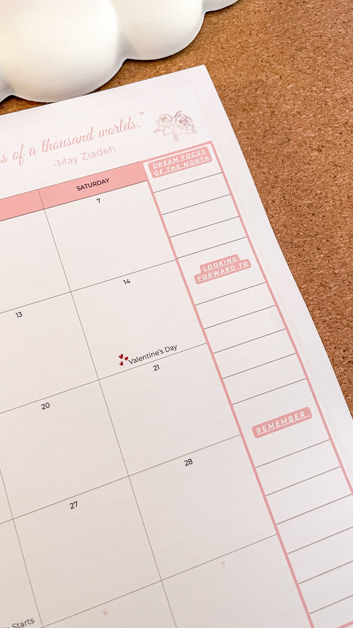 Calendar sheet with pink borders on a cork surface
